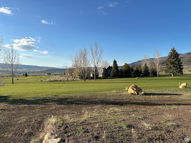 surrounding community with a yard and a mountain view