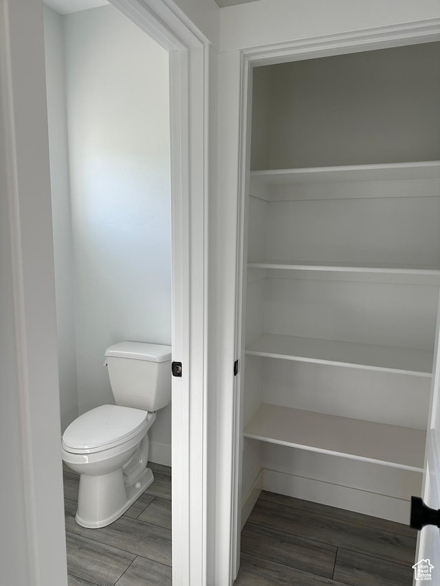 interior space featuring toilet, wood finished floors, and baseboards
