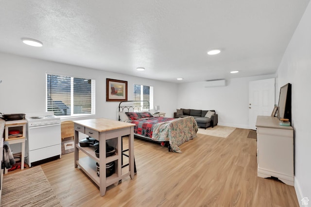 bedroom with baseboards, light wood-style flooring, recessed lighting, an AC wall unit, and a textured ceiling