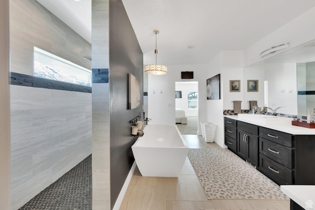 full bathroom featuring vanity, baseboards, and a freestanding bath