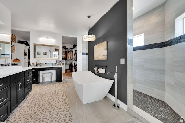 bathroom featuring a spacious closet, a freestanding bath, vanity, and walk in shower