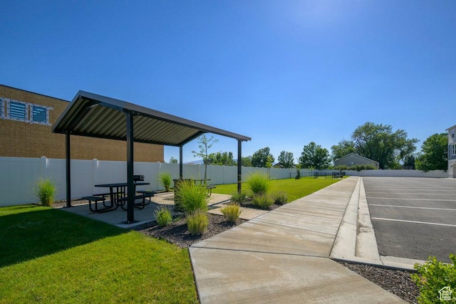 view of community featuring a yard, fence private yard, and a patio area