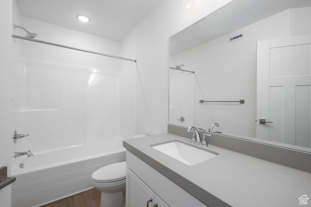 bathroom featuring visible vents, toilet, shower / tub combination, wood finished floors, and vanity