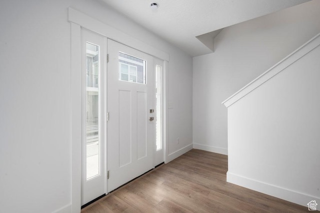 entrance foyer featuring baseboards and wood finished floors