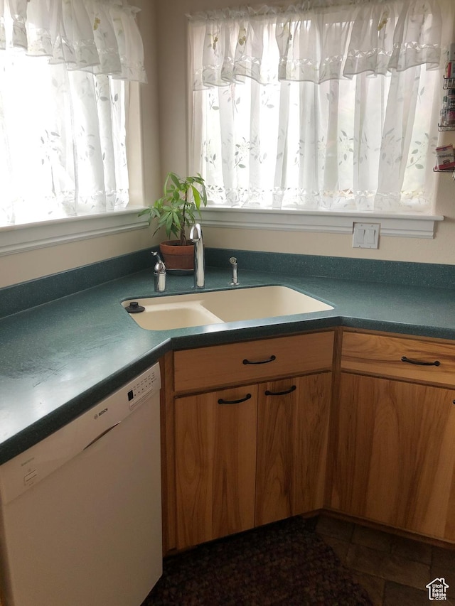 4710 Luna Cir, Moab, UT 84532 - kitchen featuring dishwasher, dark countertops, brown cabinets, and a sink
