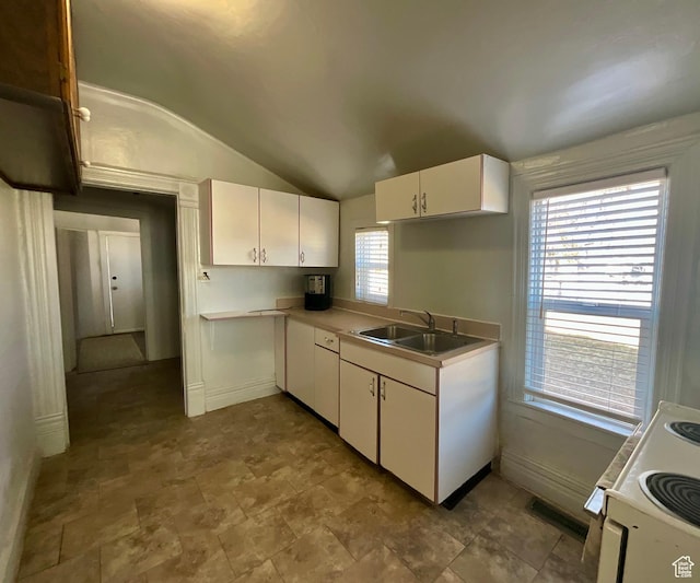 kitchen with visible vents, white range with electric cooktop, a sink, white cabinets, and lofted ceiling