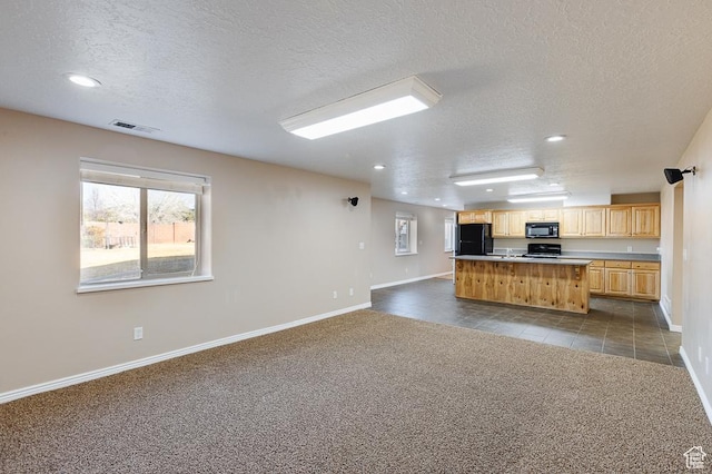 841 E Nichols Canyon Rd, Cedar City, UT 84721 - kitchen with visible vents, open floor plan, a center island with sink, dark carpet, and black appliances