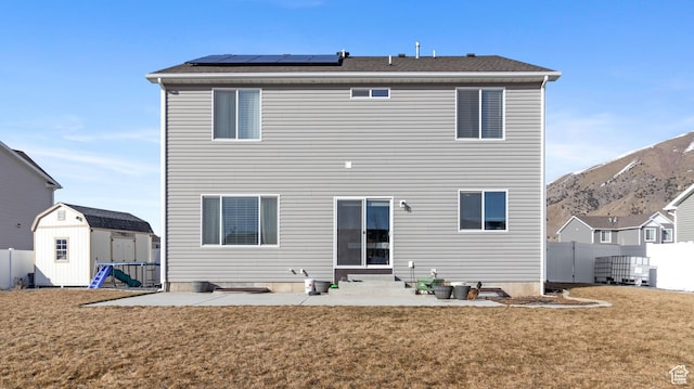 1474 E 480 S, Hyrum, UT 84319 - back of house featuring a storage unit, an outbuilding, entry steps, roof mounted solar panels, and a yard