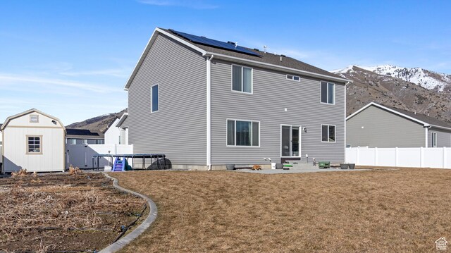1474 E 480 S, Hyrum, UT 84319 - back of house featuring an outbuilding, solar panels, a mountain view, and a storage shed