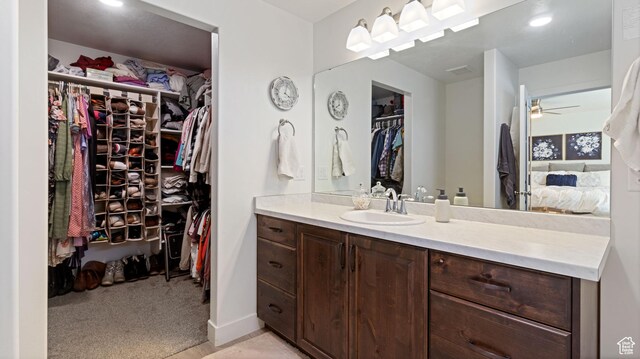 1474 E 480 S, Hyrum, UT 84319 - ensuite bathroom featuring a walk in closet, ensuite bathroom, baseboards, ceiling fan, and vanity