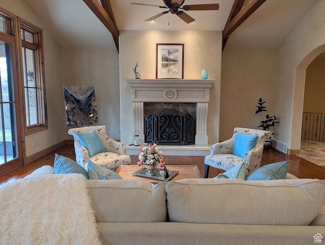 living room featuring visible vents, arched walkways, a ceiling fan, and wood finished floors