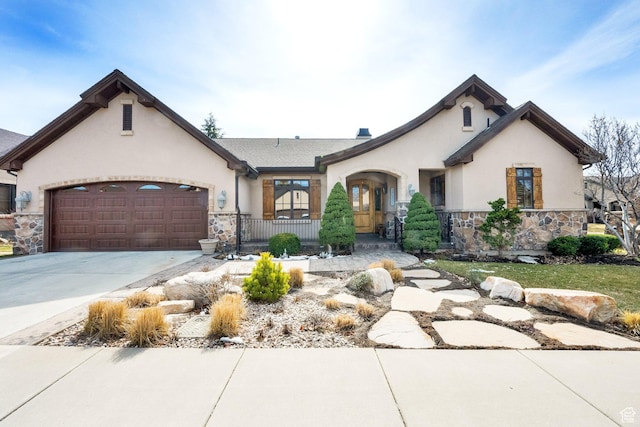 view of front of property with stone siding, driveway, stucco siding, and an attached garage