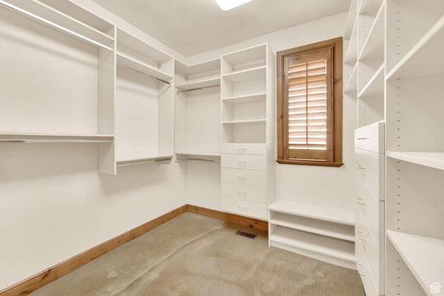 walk in closet featuring light colored carpet and visible vents