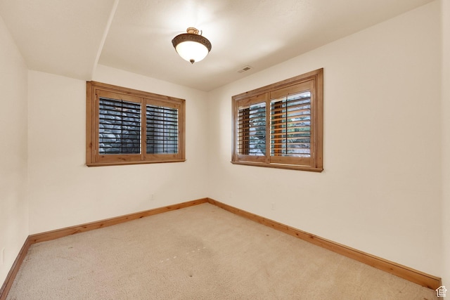 empty room with baseboards, visible vents, and carpet floors
