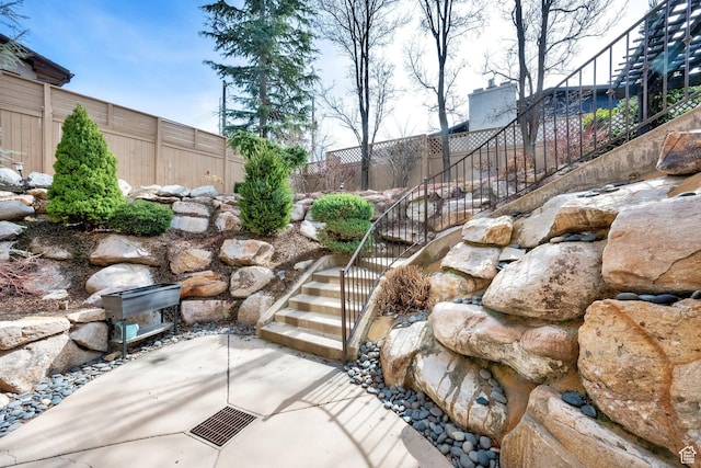 view of yard with a patio, stairway, and a fenced backyard