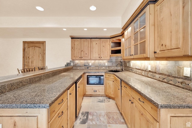 kitchen featuring light brown cabinetry, backsplash, a sink, black microwave, and a peninsula