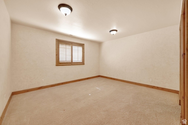 spare room with carpet and baseboards