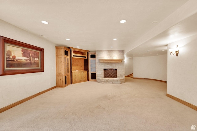 unfurnished living room with baseboards, recessed lighting, light carpet, and a stone fireplace