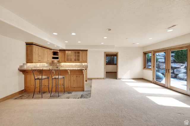 kitchen with open shelves, light colored carpet, baseboards, french doors, and a peninsula