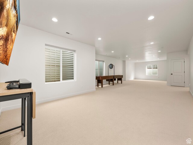 below grade area with baseboards, recessed lighting, visible vents, and light carpet