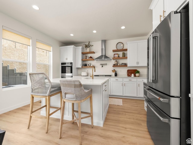 kitchen with open shelves, light countertops, white cabinetry, wall chimney range hood, and high quality fridge
