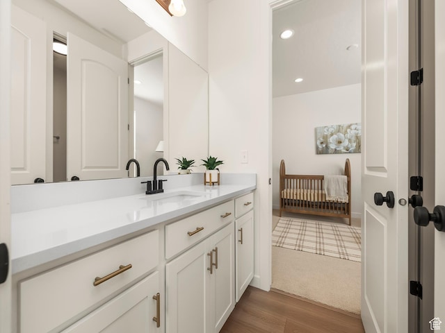 bathroom with recessed lighting, vanity, and wood finished floors