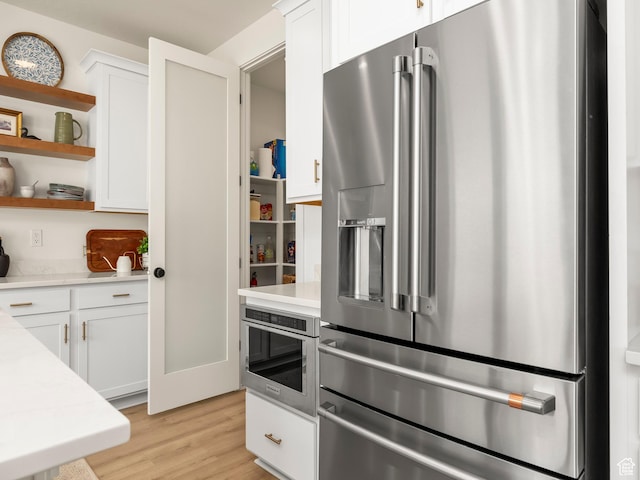 kitchen with open shelves, stainless steel fridge with ice dispenser, light countertops, white cabinets, and light wood-style floors