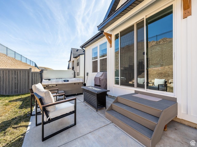 view of patio / terrace featuring fence, area for grilling, and a hot tub