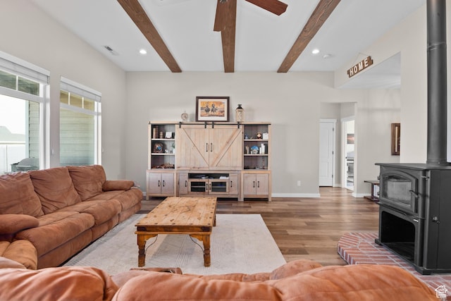 1984 S 4300 W, Ogden, UT 84401 - living area with a wood stove, a ceiling fan, visible vents, wood finished floors, and beam ceiling