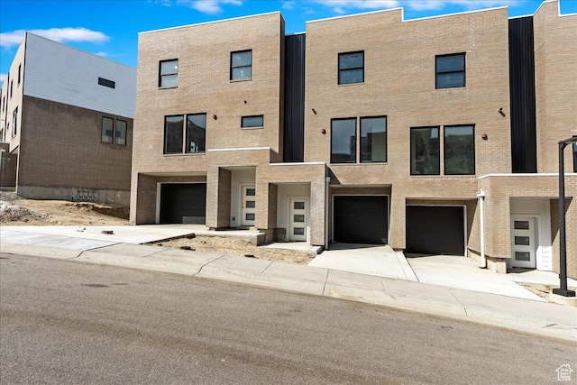exterior space featuring brick siding, a garage, and driveway