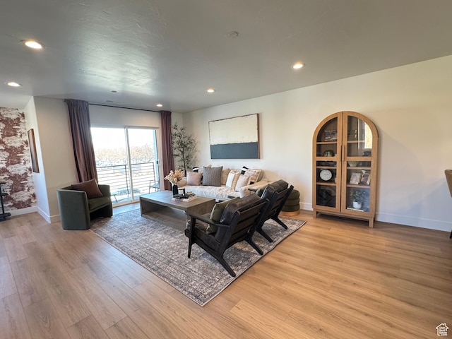 living area with recessed lighting, baseboards, and light wood-style flooring