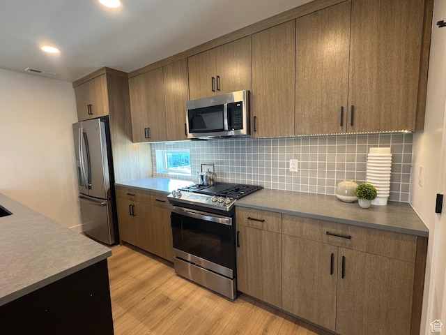 kitchen featuring light wood finished floors, visible vents, tasteful backsplash, recessed lighting, and stainless steel appliances