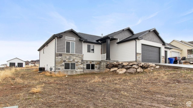 1081 N 2800 W, Tremonton, UT 84337 - view of front of house featuring stone siding, an attached garage, concrete driveway, and central AC