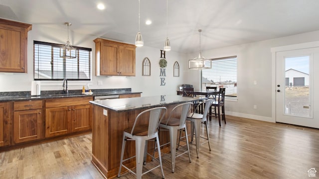1081 N 2800 W, Tremonton, UT 84337 - kitchen with brown cabinetry, light wood-style flooring, a center island, and a sink