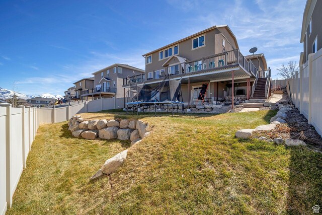 4726 W Plainfield Rd S, Herriman, UT 84096 - rear view of property featuring stairway, a yard, a trampoline, and a fenced backyard
