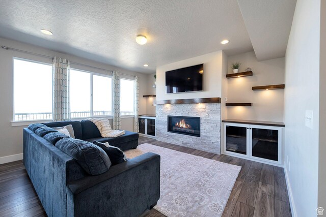 4726 W Plainfield Rd S, Herriman, UT 84096 - living room featuring dark wood finished floors, a fireplace, baseboards, and a textured ceiling
