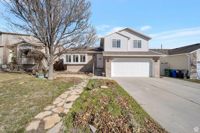 tri-level home with brick siding, driveway, and a garage