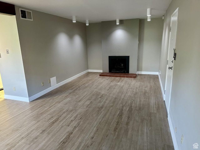 1170 S Foothill Dr Unit 311, Salt Lake City, UT 84108 - unfurnished living room with wood finished floors and a fireplace with raised hearth