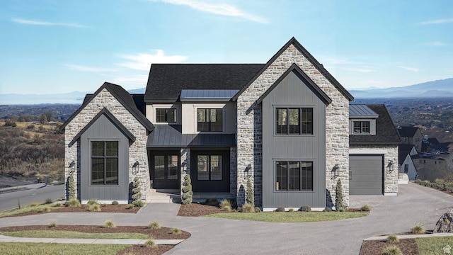 view of front of home featuring a standing seam roof, aphalt driveway, a mountain view, metal roof, and a garage