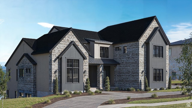 view of front of house with metal roof, stone siding, board and batten siding, and a standing seam roof