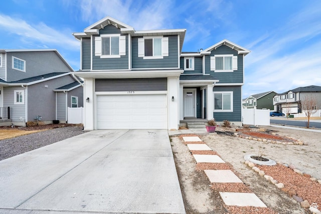 view of front of property with a garage, concrete driveway, and fence