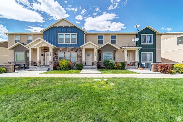 8052 N Rock Creek Cove Ln, Eagle Mountain, UT 84005 - craftsman-style home with stone siding, board and batten siding, and a front lawn