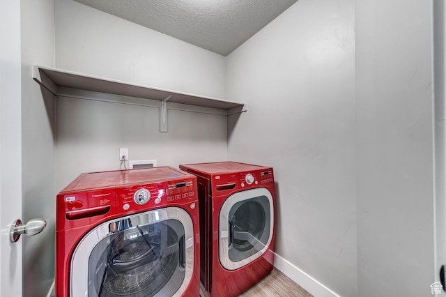 8052 N Rock Creek Cove Ln, Eagle Mountain, UT 84005 - laundry area with baseboards, laundry area, wood finished floors, washer and dryer, and a textured ceiling