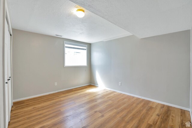 1354 N 2950 W, Clinton, UT 84015 - empty room with light wood-style flooring, baseboards, visible vents, and a textured ceiling