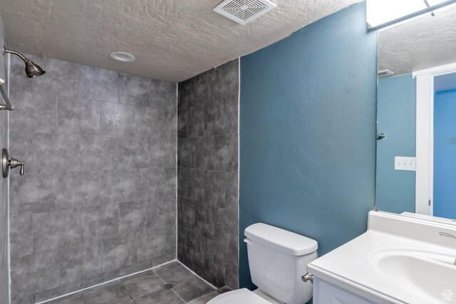 252 E 31st S, Ogden, UT 84401 - bathroom with toilet, visible vents, a tile shower, and a textured ceiling