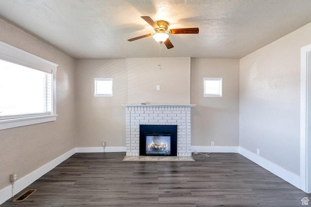 252 E 31st S, Ogden, UT 84401 - unfurnished living room featuring visible vents, a brick fireplace, baseboards, wood finished floors, and a textured ceiling