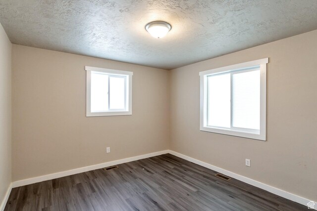 252 E 31st S, Ogden, UT 84401 - empty room with visible vents, plenty of natural light, baseboards, and dark wood-style flooring