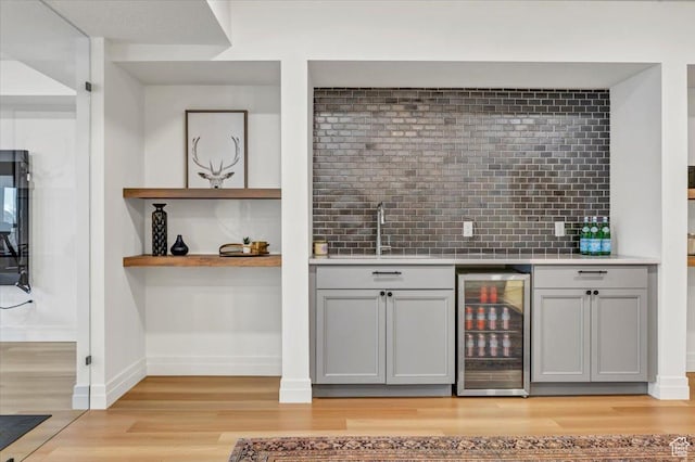 4875 N Vialetto Way, Lehi, UT 84043 - bar with light wood-style flooring, beverage cooler, a sink, backsplash, and wet bar