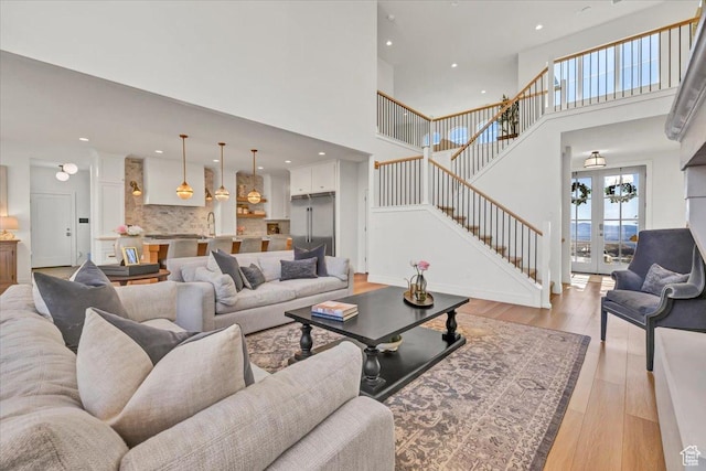 4875 N Vialetto Way, Lehi, UT 84043 - living room with recessed lighting, stairway, french doors, light wood-style floors, and a towering ceiling