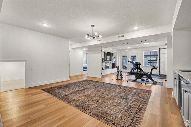 4875 N Vialetto Way, Lehi, UT 84043 - workout room with light wood finished floors, visible vents, baseboards, a notable chandelier, and a textured ceiling
